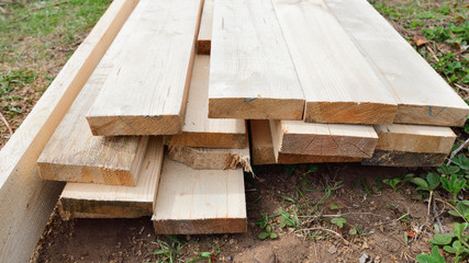 a pile of rough planed pine planks on the ground