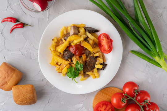 yellow fried potapo with mushrooms and tomatoe, different vegetables and sauce lay arounds