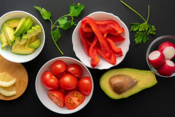 top view assorted sliced fresh vegetables in white bowls, ingredients for cooking salads