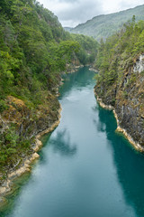 An amazing landscape at north Chilean Patagonia, Puelo river moves around the narrow gorge with its turquoise waters on an awe idyllic natural environment outdoor rugged landscape under a dramatic sky