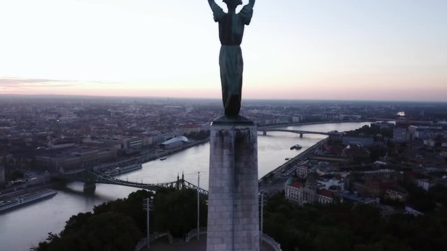 Aerial footage by the liberty statue of Budapest, Hungary, with a general view the city during early morning light.
