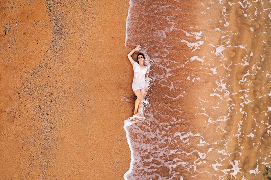 Woman Lying On Sand, From Above