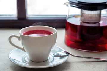 Cup of tea and a teapot on a window