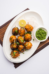 Tandoori aloo are roasted potatoes with Indian spices. It's a party appetiser served with green chutney. selective focus