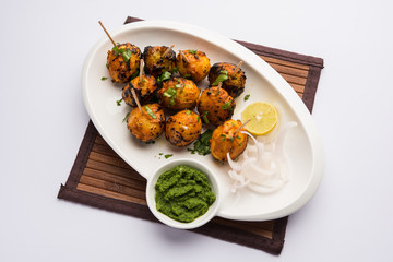 Tandoori aloo are roasted potatoes with Indian spices. It's a party appetiser served with green chutney. selective focus