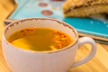 Sea buckthorn tea with millefeuille cake on wooden table