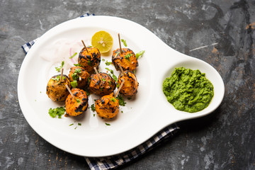 Tandoori aloo are roasted potatoes with Indian spices. It's a party appetiser served with green chutney. selective focus