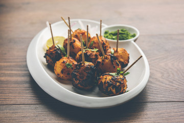 Tandoori aloo are roasted potatoes with Indian spices. It's a party appetiser served with green chutney. selective focus