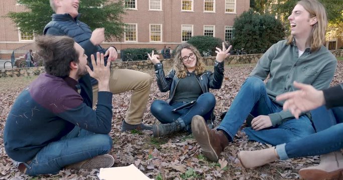 Two college friends playing rock paper scissors to break a tie on campus
