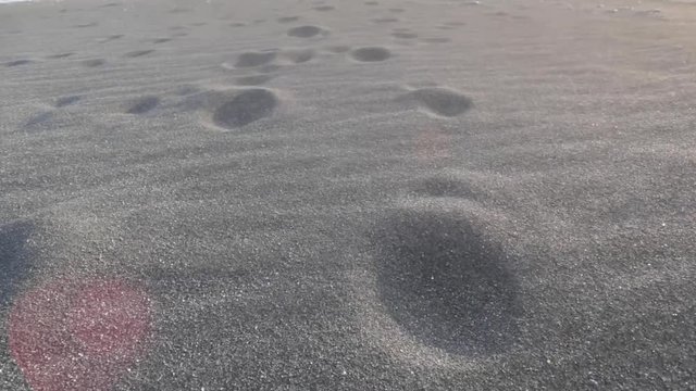 Footprints in on a windy day at the Black Sand Beach in Iceland.