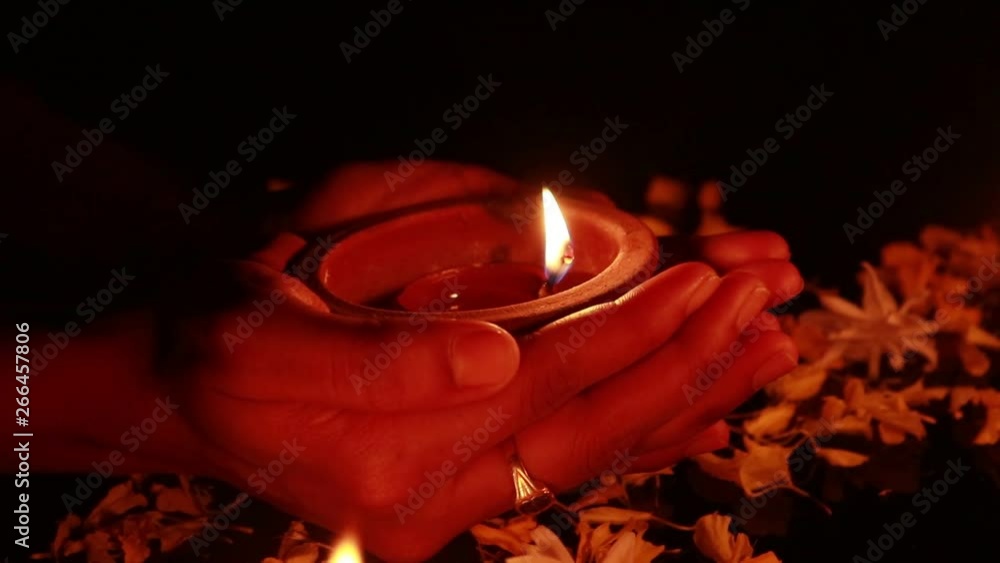 Poster hands slowly placing a mud lamp in the dark