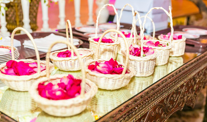 close up on color rose petals in a red flower girl basket for a wedding bridal