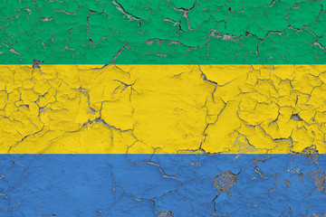 Flag of Gabon painted on cracked dirty wall. National pattern on vintage style surface.