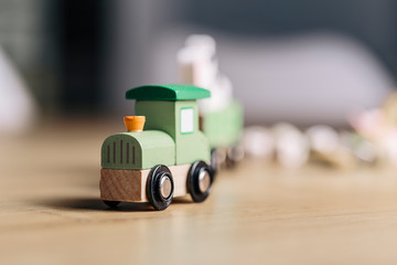 Green toy wooden train close up on a wooden surface