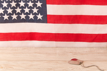 Obraz premium Army badges on a wooden table and an American flag in the background. Veterans Day.