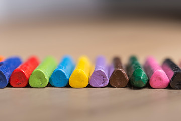 Colourful crayons for drawing together in a row on a wooden background