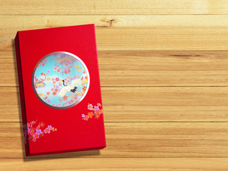 Red premium Chinese gift box for Chinese New Year, Anniversary, Mid-Autumn Festival, Valentine's Day, Birthday. On wooden background.