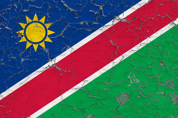 Flag of Namibia painted on cracked dirty wall. National pattern on vintage style surface.