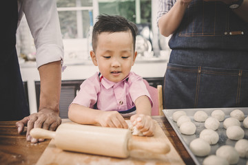 Fototapeta premium happy family in kitchen. family knead dough and bake the bakery together in kitchen