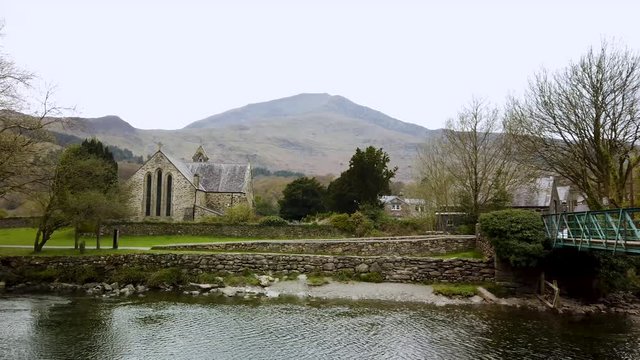 River Glaslyn, Beddgelert, North Wales, UK - showing the mountain Moel Hebog in the background and the Church of St Mary.