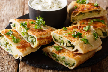 Afghani Bolani with mashed potato & Green Onions served with plain yogurt closeup. horizontal