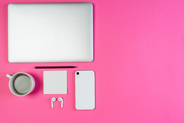 Laptop Phone Coffee on Pink Workspace Flat Lay with Copy Space. White Smartphone, Earphone and Pencil on Minimal Clear Layout Background with Paper Note. Business Workspace Order Inspiration Concept