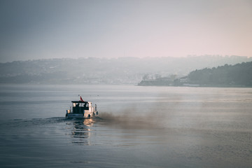 small boat filling the air with smoke and pollution from his engine