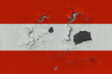Close up grungy, damaged and weathered Austria flag on wall peeling off paint to see inside surface.