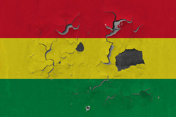Close up grungy, damaged and weathered Bolivia flag on wall peeling off paint to see inside surface.