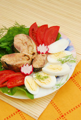 Plate with sardines tomatoes and aromatic herbs on a table