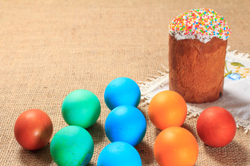 Painted eggs and Easter cake on sackcloth.