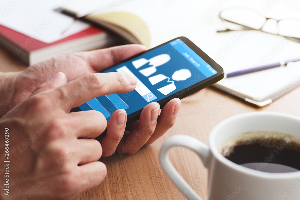 Poster Online job search concept. Using smartphone and app.Closeup of male hands touching smartphone screen for using app at table.