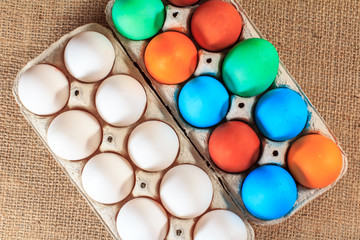 White and colored easter eggs on sackcloth.