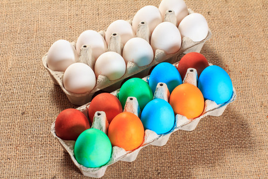 White and colored easter eggs on sackcloth.