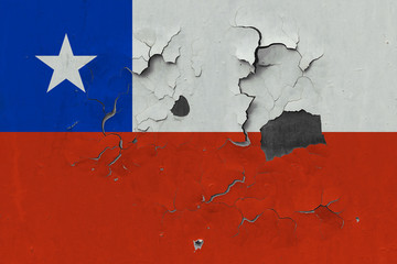 Close up grungy, damaged and weathered Chile flag on wall peeling off paint to see inside surface.