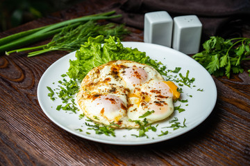 Flat lay of tasty breakfast over grey concrete table background. Fried eggs, micro greens, fresh tomatoes in plate, top view. Clean eating, dieting, vegetarian food - Image