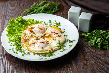 Flat lay of tasty breakfast over grey concrete table background. Fried eggs, micro greens, fresh tomatoes in plate, top view. Clean eating, dieting, vegetarian food - Image