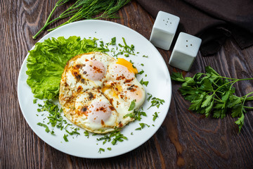 Flat lay of tasty breakfast over grey concrete table background. Fried eggs, micro greens, fresh tomatoes in plate, top view. Clean eating, dieting, vegetarian food - Image