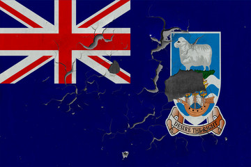 Close up grungy, damaged and weathered Falkland Islands flag on wall peeling off paint to see...