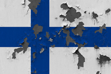 Close up grungy, damaged and weathered Finland flag on wall peeling off paint to see inside surface.