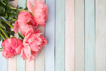 pink peony flowers on pastl colors wooden table. mother's day or wedding background with copy space. Flat lay. Top view