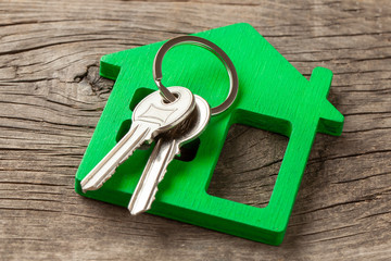Wooden green house and keys on old wooden boards