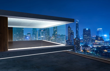 Fototapeta premium Empty glass wall balcony with city skyline view . Night scene .Mixed media .