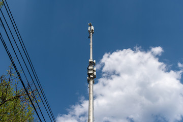 Cell tower against the blue sky with clouds