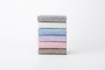 Stacked towels in blue, white, pink, and grey
