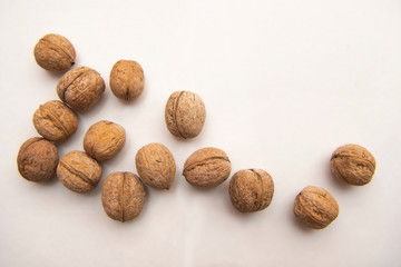 

walnut stands a lot on the table. greek nut and coffee beans on a bamboo mat, on a white background.