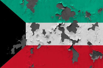 Close up grungy, damaged and weathered Kuwait flag on wall peeling off paint to see inside surface.