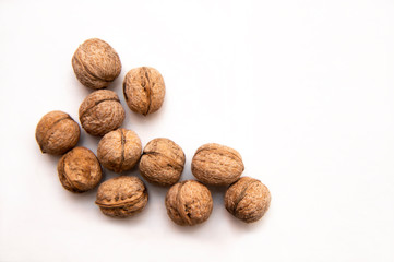 

walnut stands a lot on the table. greek nut and coffee beans on a bamboo mat, on a white background.