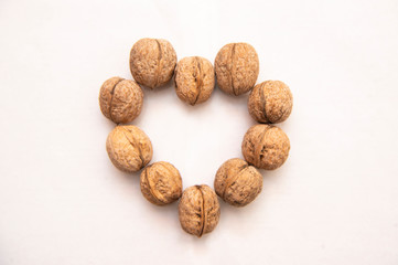 

walnut stands a lot on the table. greek nut and coffee beans on a bamboo mat, on a white background.