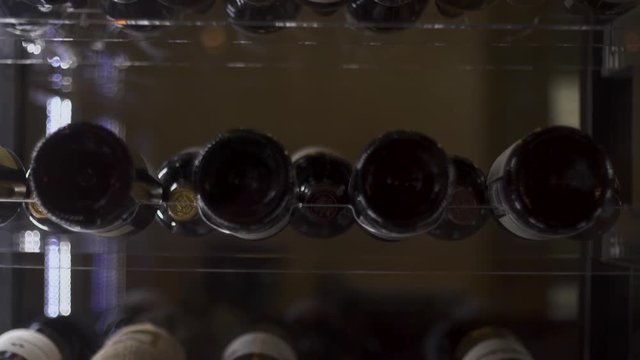 Stand with bottles of wine in the restaurant. Stand with wine bottles without logos in the frame